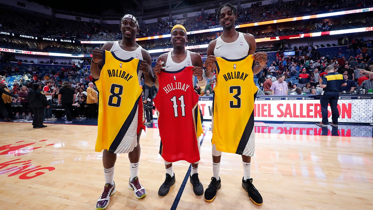 New Orleans Pelicans guard Jrue Holiday, left, swaps jerseys with his brothers Indiana Pacers guard Aaron Holiday, center, and Pacers forward Justin Holiday, right, after an NBA basketball game in New Orleans, Saturday, Dec. 28, 2019. The Pelicans won 120-98. (AP Photo/Gerald Herbert)