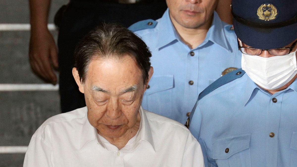 In this June 3, 2019, file photo, Hideaki Kumazawa, left, a former top Japanese government official, leaves a police station in Tokyo.