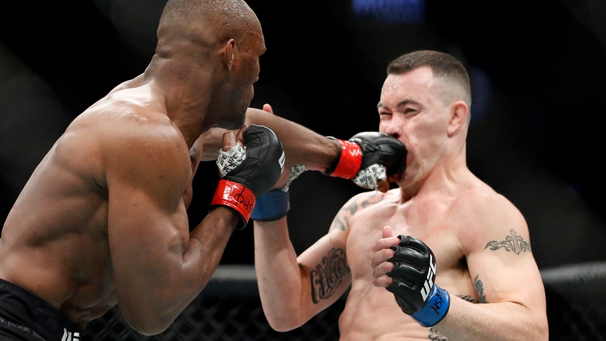 Kamaru Usman hits Colby Covington in a mixed martial arts welterweight championship bout at UFC 245, Saturday, Dec. 14, 2019, in Las Vegas. (AP Photo/John Locher)