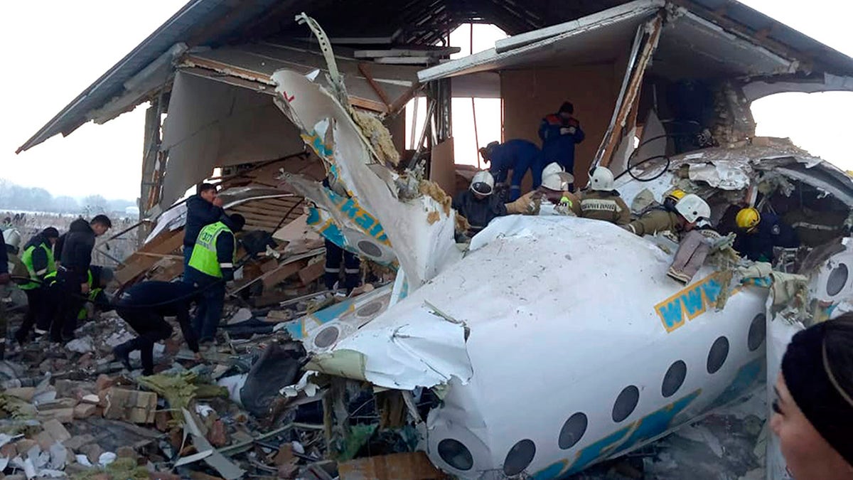 In this handout photo provided by the Emergency Situations Ministry of the Republic of Kazakhstan, police and rescuers work on the side of a plane crash near Almaty International Airport, outside Almaty, Kazakhstan, Friday, Dec. 27, 2019. Almaty International Airport said a Bek Air plane crashed Friday in Kazakhstan shortly after takeoff causing numerous deaths. The aircraft had 100 passengers and crew onboard when hit a concrete fence and a two-story building shortly after takeoff.