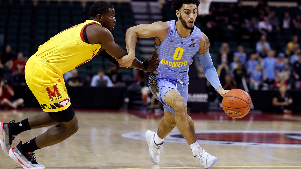 Marquette guard Markus Howard (0) is fouled by Maryland guard Darryl Morsell, left, during the first half of an NCAA college basketball game Sunday, Dec. 1, 2019, in Lake Buena Vista, Fla. (AP Photo/Scott Audette)