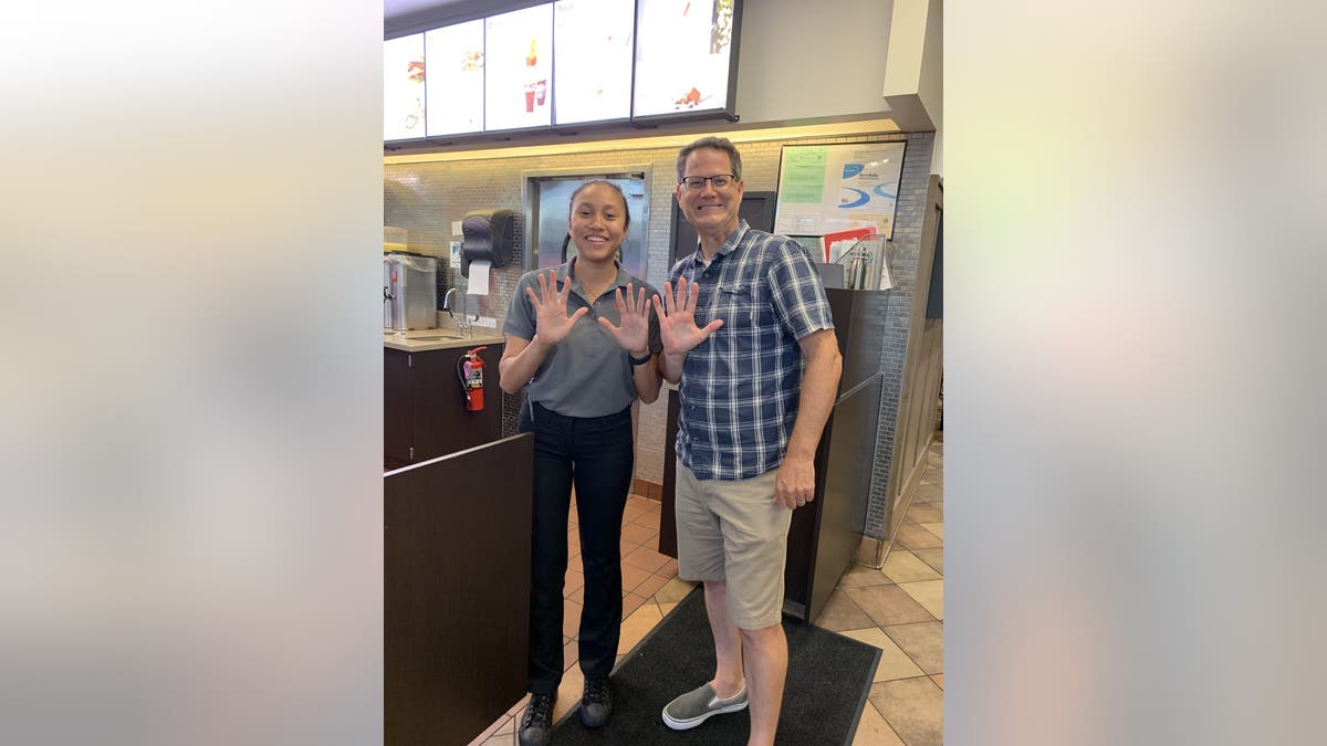 One of Mendenhall's self-imposed rules stipulated that he needed to take a photo on each visit. As seen above, Mendenhall and an employee celebrate his 15th visit in as many business days.