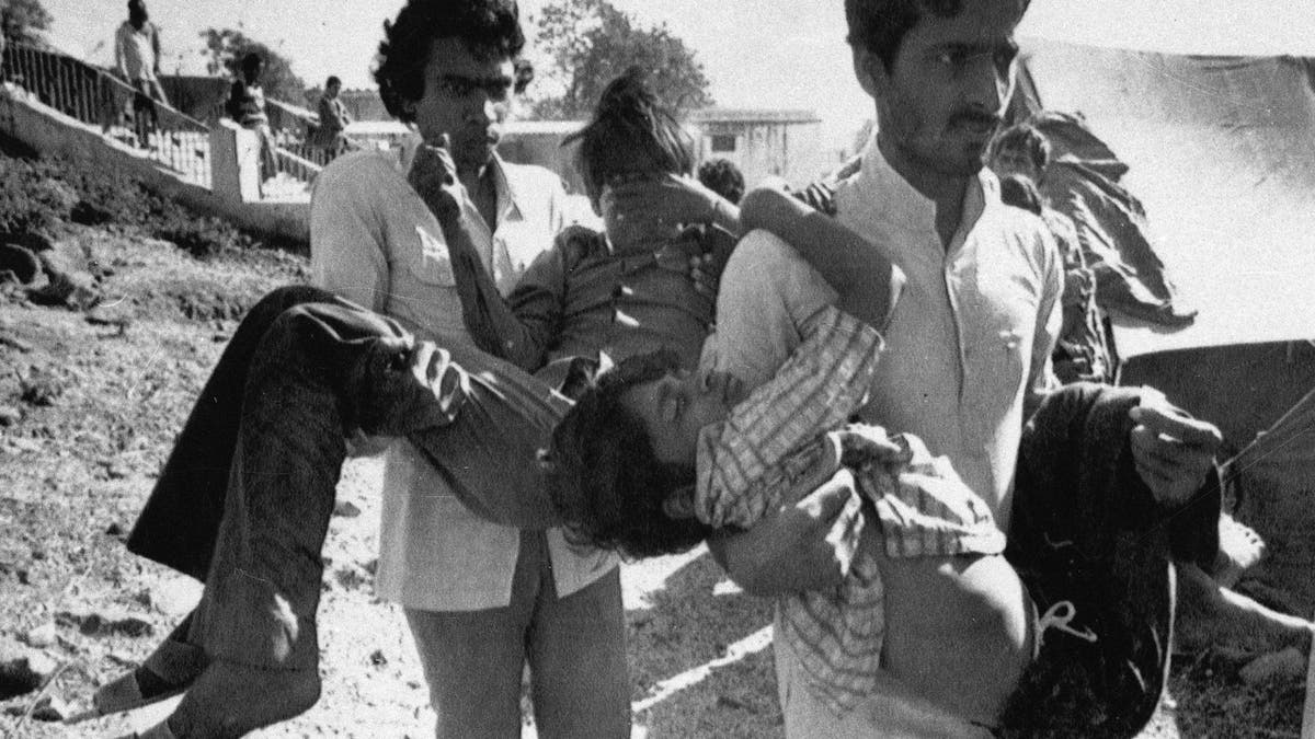 In this Dec. 5, 1984, file photo, two men carry to a hospital children blinded by the Union Carbide chemical pesticide leak in Bhopal, India. (AP Photo/Sondeep Shankar, File)