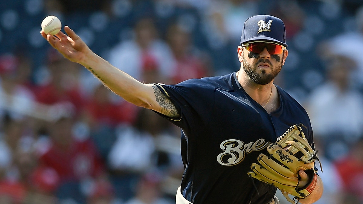FILE - In this Aug. 18, 2019, file photo, Milwaukee Brewers third baseman Mike Moustakas throws the ball to first during a baseball game against the Washington Nationals in Washington. (AP Photo/Nick Wass, File)