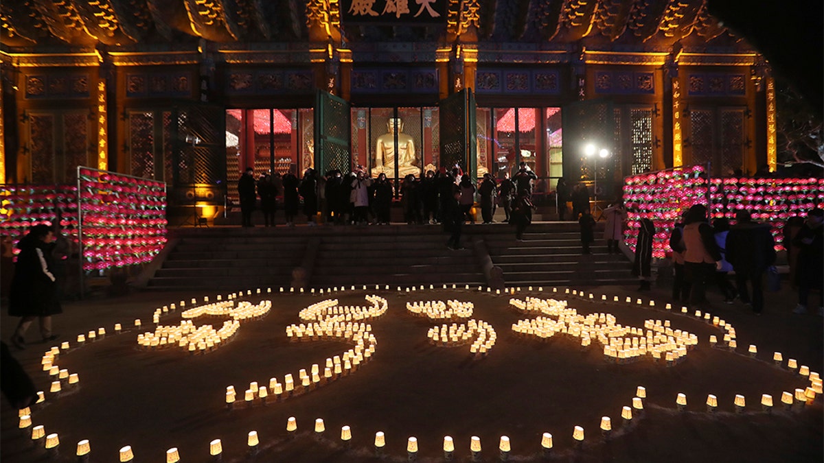 Buddhists light candles to form letters meaning, "Best wishes for a Happy New Year," during New Year celebrations at Jogyesa Buddhist temple in Seoul, South Korea, Wednesday, Jan. 1, 2020. (Associated Press)