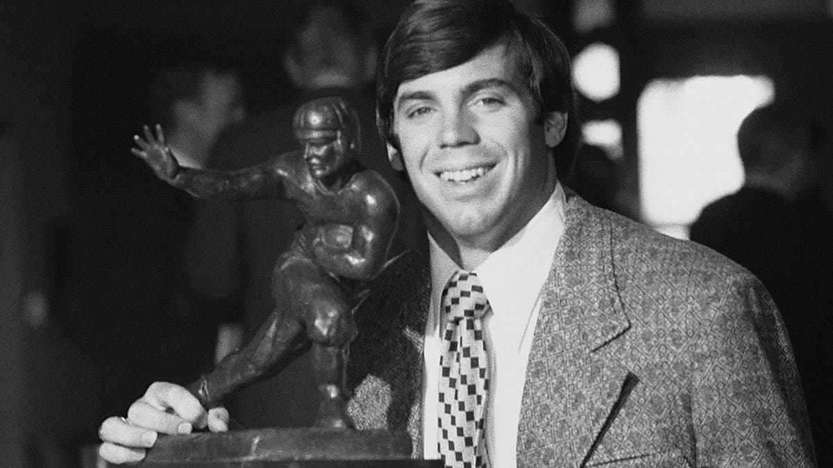 FILE - In this Dec. 2, 1971, file photo, Auburn quarterback Pat Sullivan poses with his Heisman Trophy after the presentation at the Downtown Athletic Club in New York. Sullivan, the 1971 Heisman Trophy winner at Auburn who went on to coach TCU and Samford, died Sunday, Dec. 1, 2019. He was 69. (AP Photo/Anthony Camerano, File)