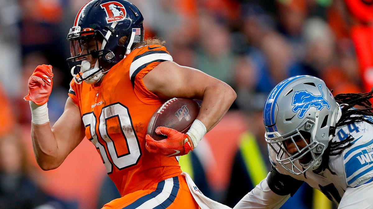 Denver Broncos running back Phillip Lindsay (30) breaks free from the grasp of Detroit Lions linebacker Jalen Reeves-Maybin (44) for a touchdown during the second half of an NFL football game, Sunday, Dec. 22, 2019, in Denver. (AP Photo/David Zalubowski)