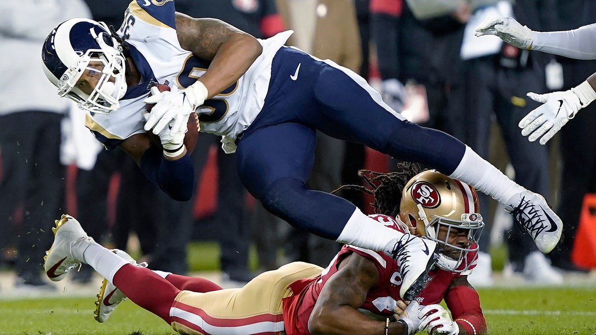 Los Angeles Rams running back Todd Gurley II (30) is tackled by San Francisco 49ers cornerback Richard Sherman, bottom, during the second half of an NFL football game in Santa Clara, Calif., Saturday, Dec. 21, 2019. (AP Photo/Tony Avelar)