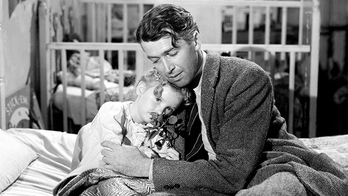 American actors James Stewart (1908 - 1997), as George Bailey, and Karolyn Grimes as his daughter Zuzu, in a scene from "It's a Wonderful Life." The film was directed by Frank Capra in 1946.