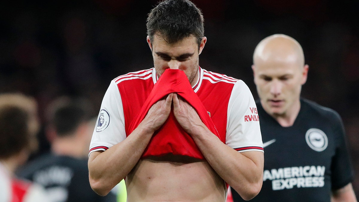 Arsenal's Sokratis Papastathopoulos wipes his face during the English Premier League soccer match between Arsenal and Brighton, at the Emirates Stadium in London, Thursday, Dec. 5, 2019. (AP Photo/Frank Augstein)