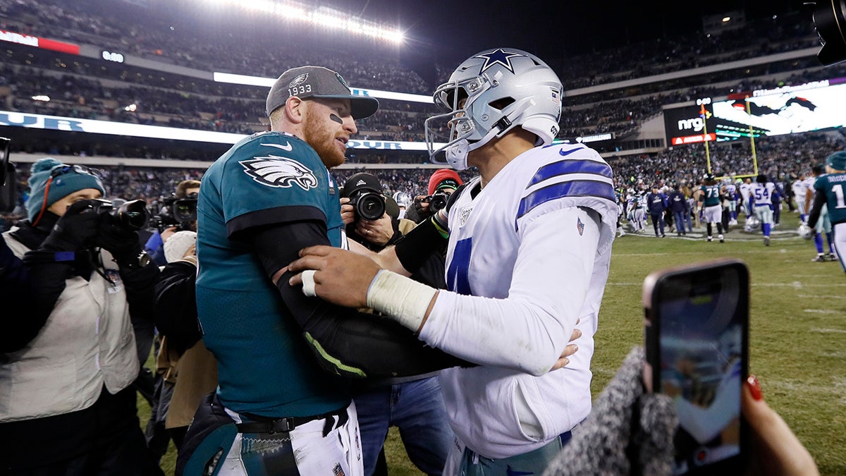 Philadelphia Eagles quarterback Carson Wentz, left, meets with Dallas Cowboys quarterback Dak Prescott after of an NFL football game Sunday, Dec. 22, 2019, in Philadelphia. (AP Photo/Michael Perez)