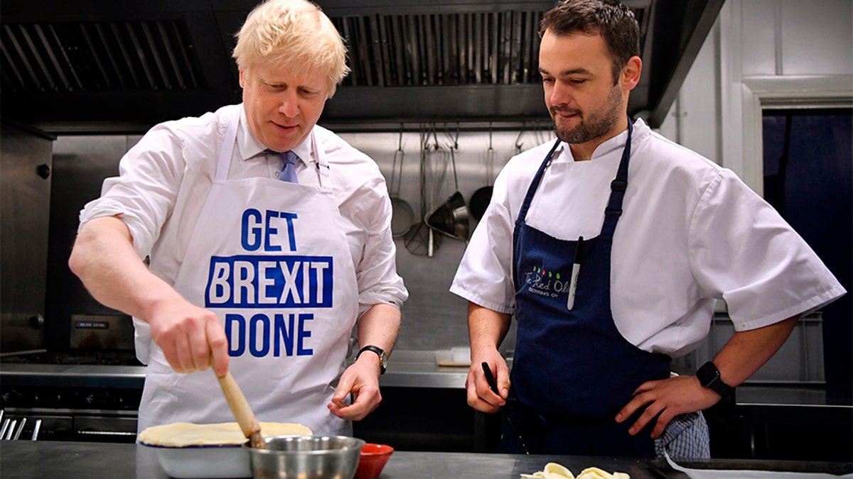 Britain's Prime Minister Boris Johnson prepares a pie at the Red Olive catering company while on the campaign trail, in Derby, England, on Wednesday.