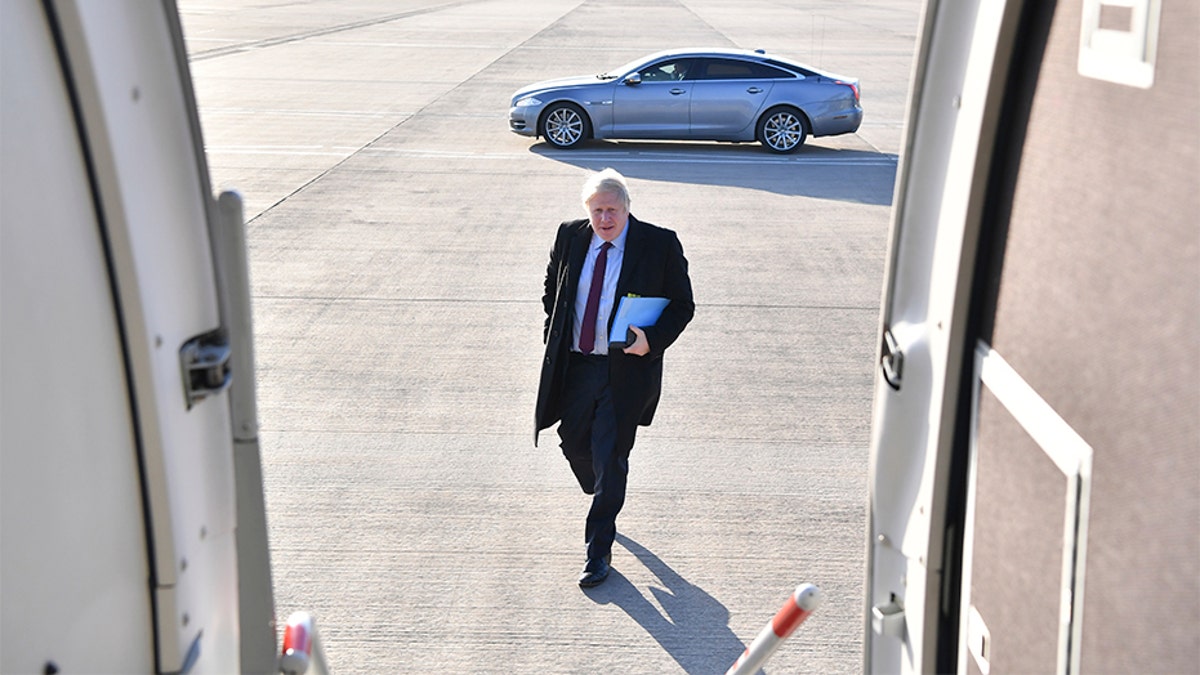 Britain's Prime Minister and Conservative Party leader Boris Johnson boards a plane at Doncaster Sheffield Airport in Doncaster, England, on Monday, during campaigning ahead of the general election on Dec. 12. 