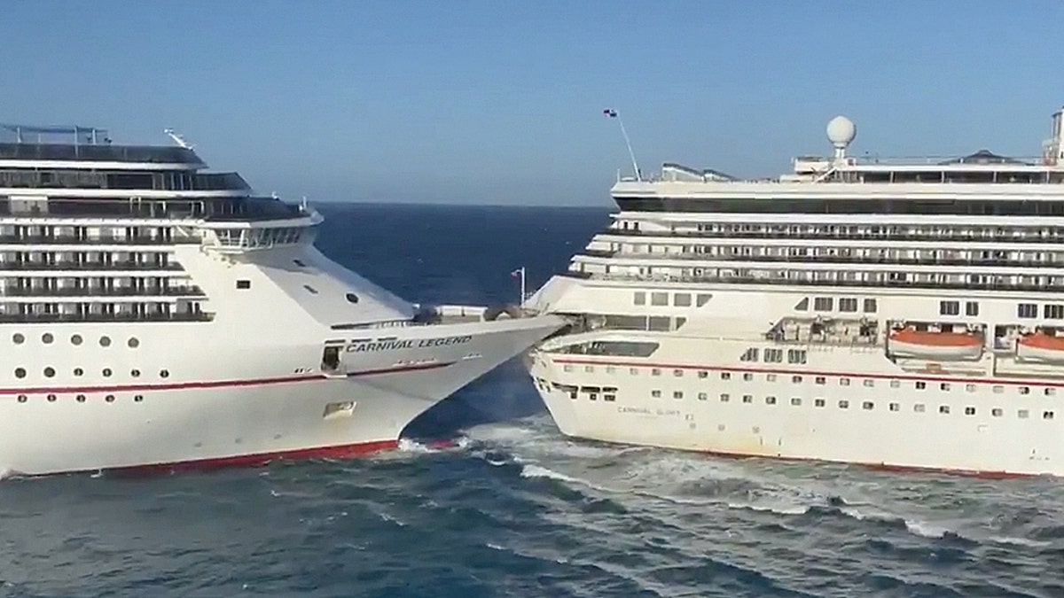 The Carnival Glory cruise ship, right, crashes into the Carnival Legend on Friday morning. The cruise line currently believes the collision was caused by “spontaneous wind gusts and strong currents.”