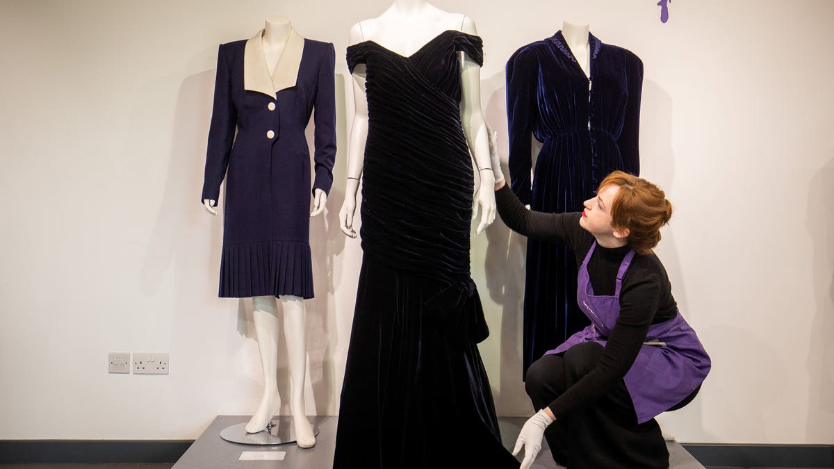 An assistant adjusts Princess Diana's iconic 'Travolta Dress' at Kerry Taylor Auctions.