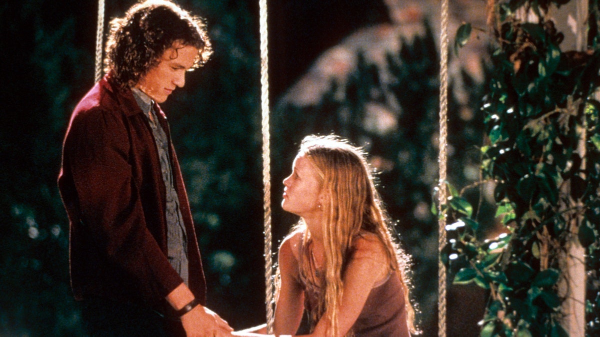 Heath Ledger and Julia Stiles at swing in a scene from the film '10 Things I Hate About You', 1999.