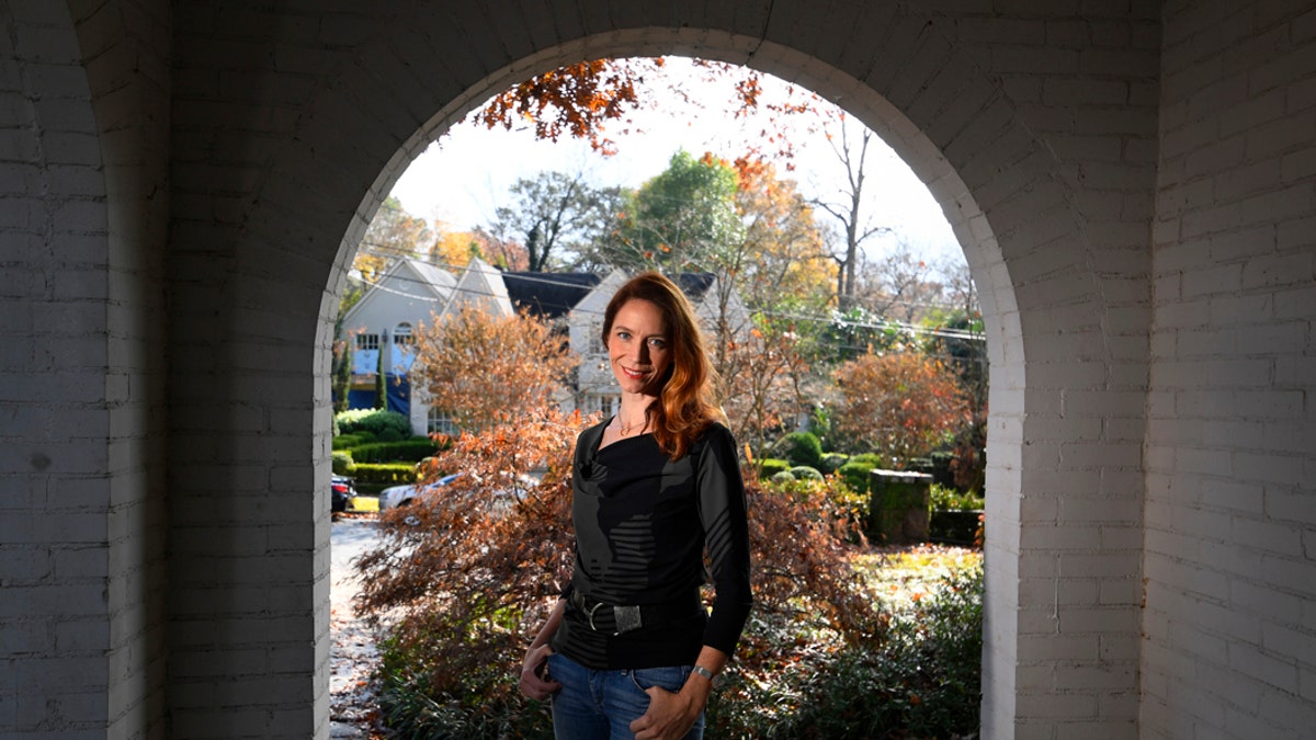 In this Nov. 27, 2019, photo, Georgia Tech professor Kim Cobb poses for a photo at her home in Atlanta. Some climate scientists and activists, including Cobb, are limiting their flying, their consumption of meat and their overall carbon footprints to avoid adding to the global warming they study. (AP Photo/John Amis)
