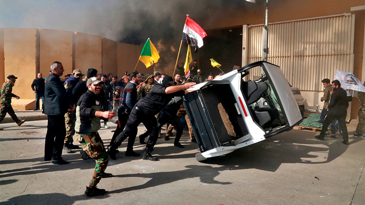 Protesters damage property inside the U.S. embassy compound, in Baghdad, Iraq, on Tuesday.