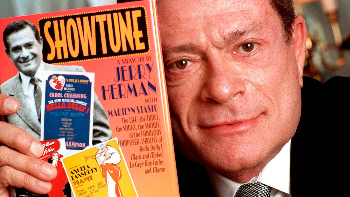 In this Nov. 19, 1996, file photo, composer Jerry Herman displays his book "Showtune," in New York.