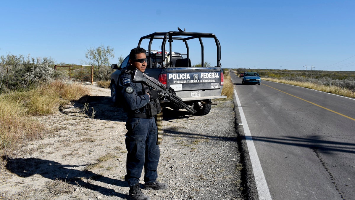 Police guard the highway leading to ViIlla Union, Mexico, Sunday, Dec. 1, 2019, the day after it was assaulted by gunmen.