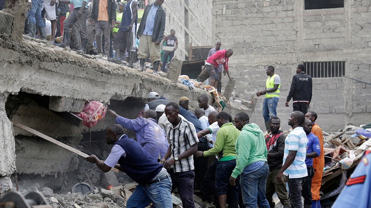 People at the scene of a collapsed building in in Tasia Embakasi, an east neighbourhood of Nairobi, Kenya on Friday Dec. 6, 2019. (Associated Press)