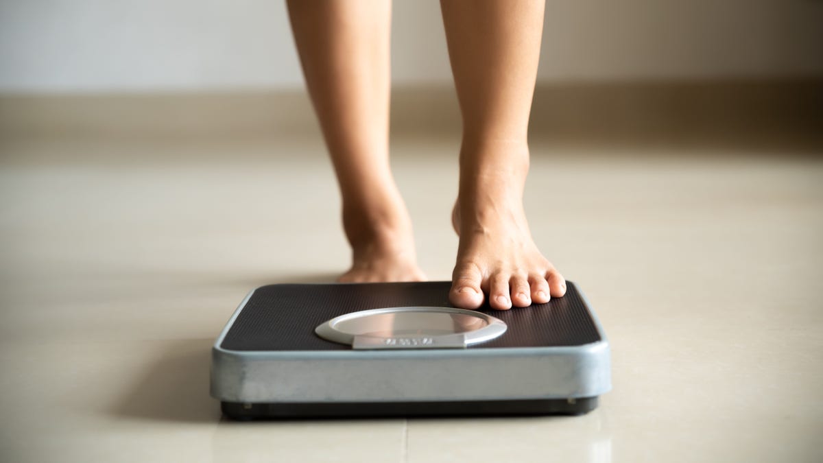 Female leg stepping on weigh scales. Healthy lifestyle, food and sport concept.