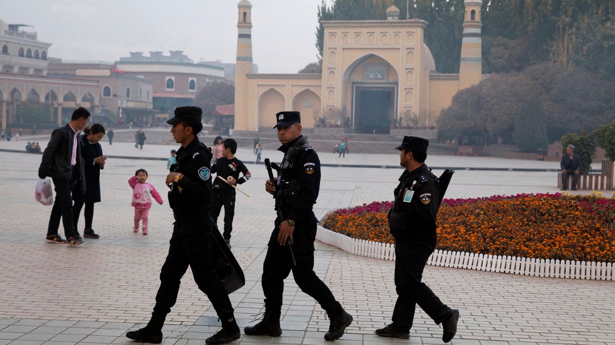 Uighur security personnel patrol near the Id Kah Mosque in Kashgar in western China's Xinjiang region. Classified documents, leaked to a consortium of news organizations, lay out the Chinese government's deliberate strategy to lock up ethnic minorities to rewire their thoughts and even the language they speak.