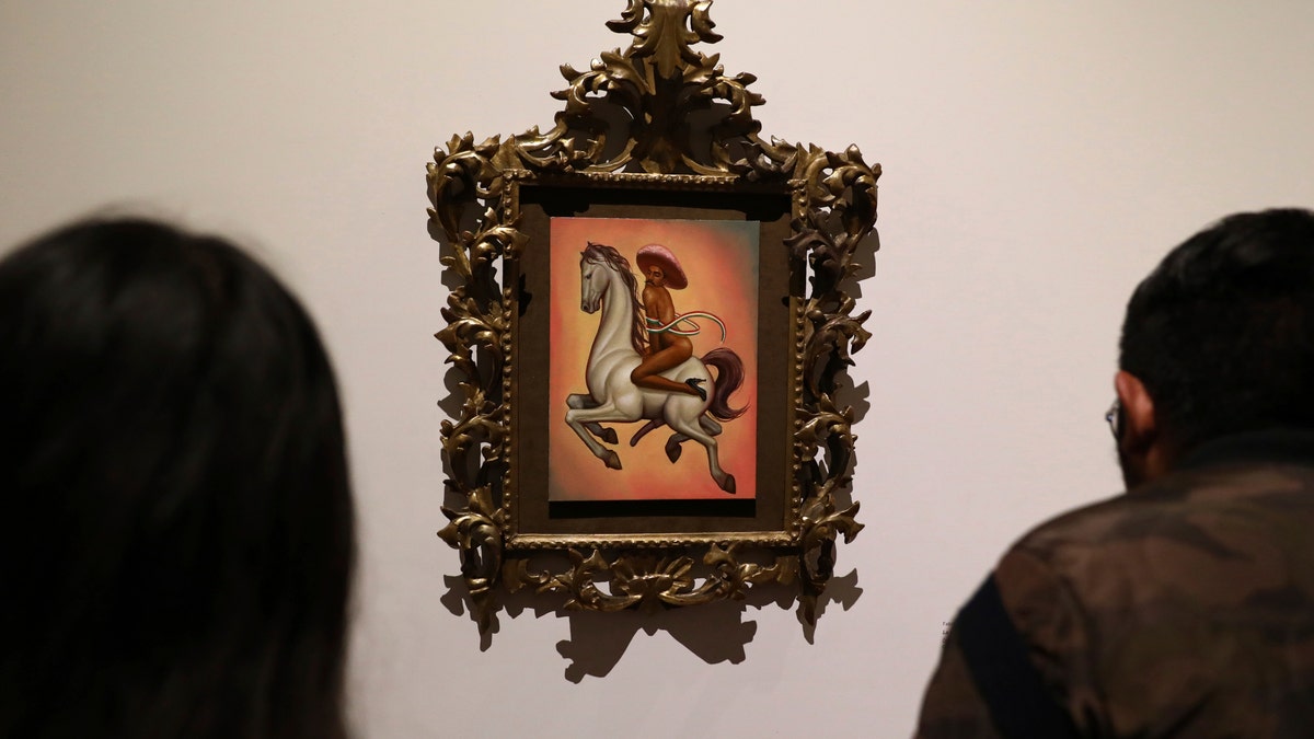 The painting shows 1910-17 Mexican revolutionary hero Emiliano Zapata nude, wearing high heels and a pink, broad-brimmed hat, straddling a horse. (AP Photo/Eduardo Verdugo)