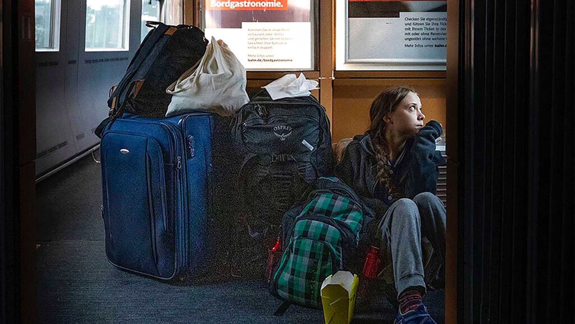 In this image taken from Twitter feed of Climate activist Greta Thunberg, showing Thunberg sitting on the floor of a train surrounded by bags Saturday Dec. 14, 2019, with the comment “traveling on overcrowded trains through Germany. And I’m finally on my way home!” (Twitter @GretaThunberg via AP)