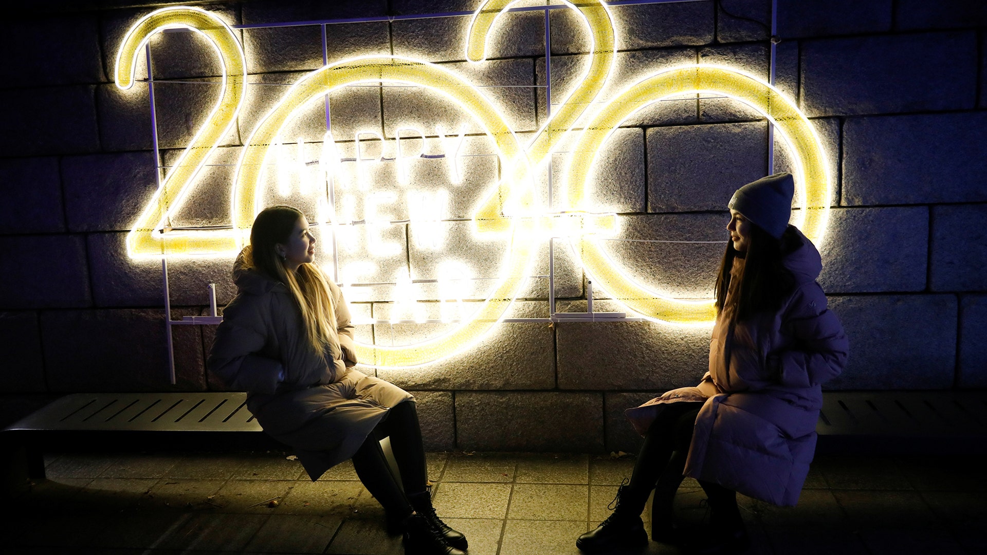 Seoul, South Korea: Women pose for a picture in front of a 2020 luminous sign during New Year's Eve celebrations.