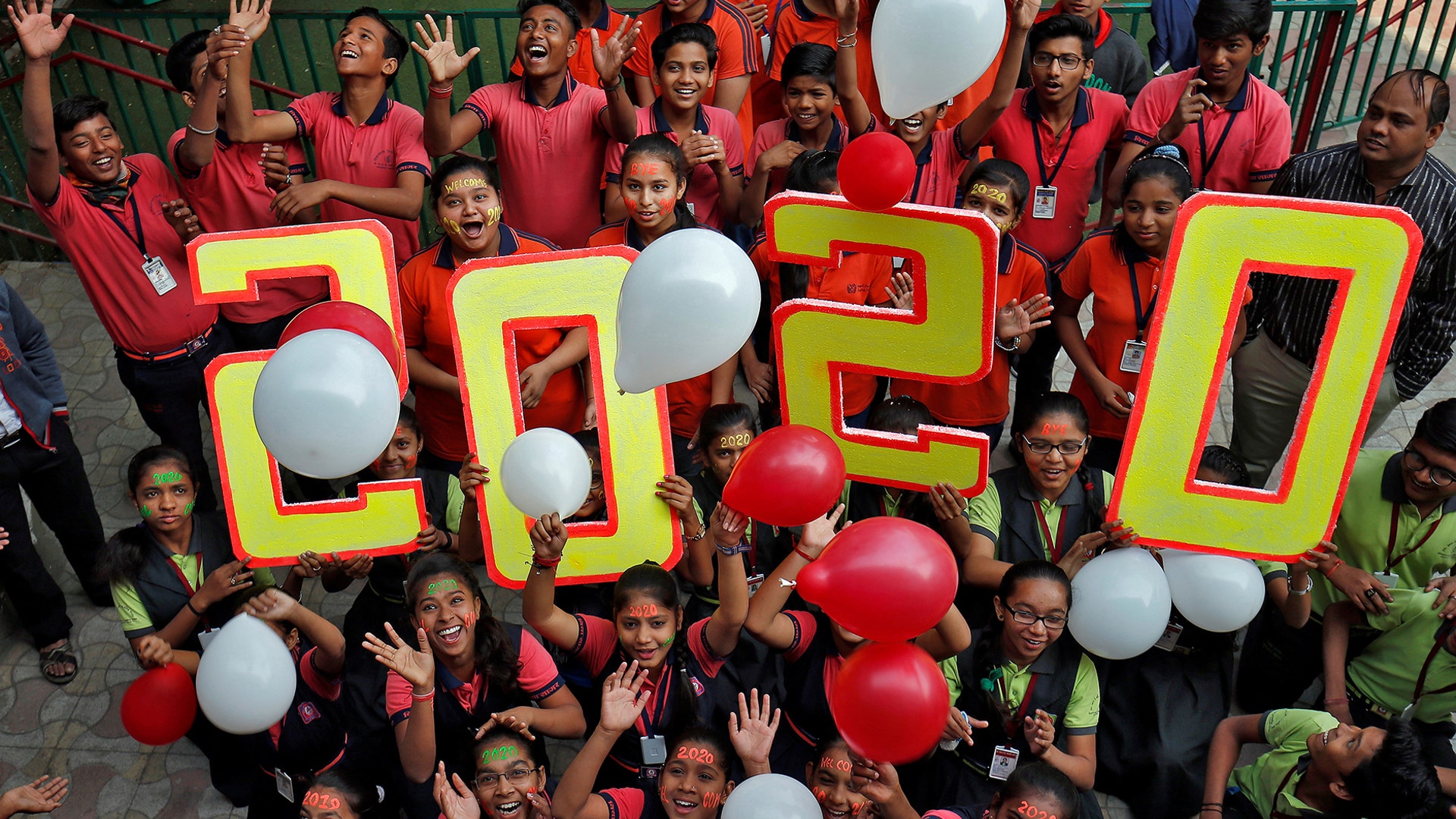 Ahmedabad, India: Students cheer as they release balloons during celebrations to welcome the New Year.