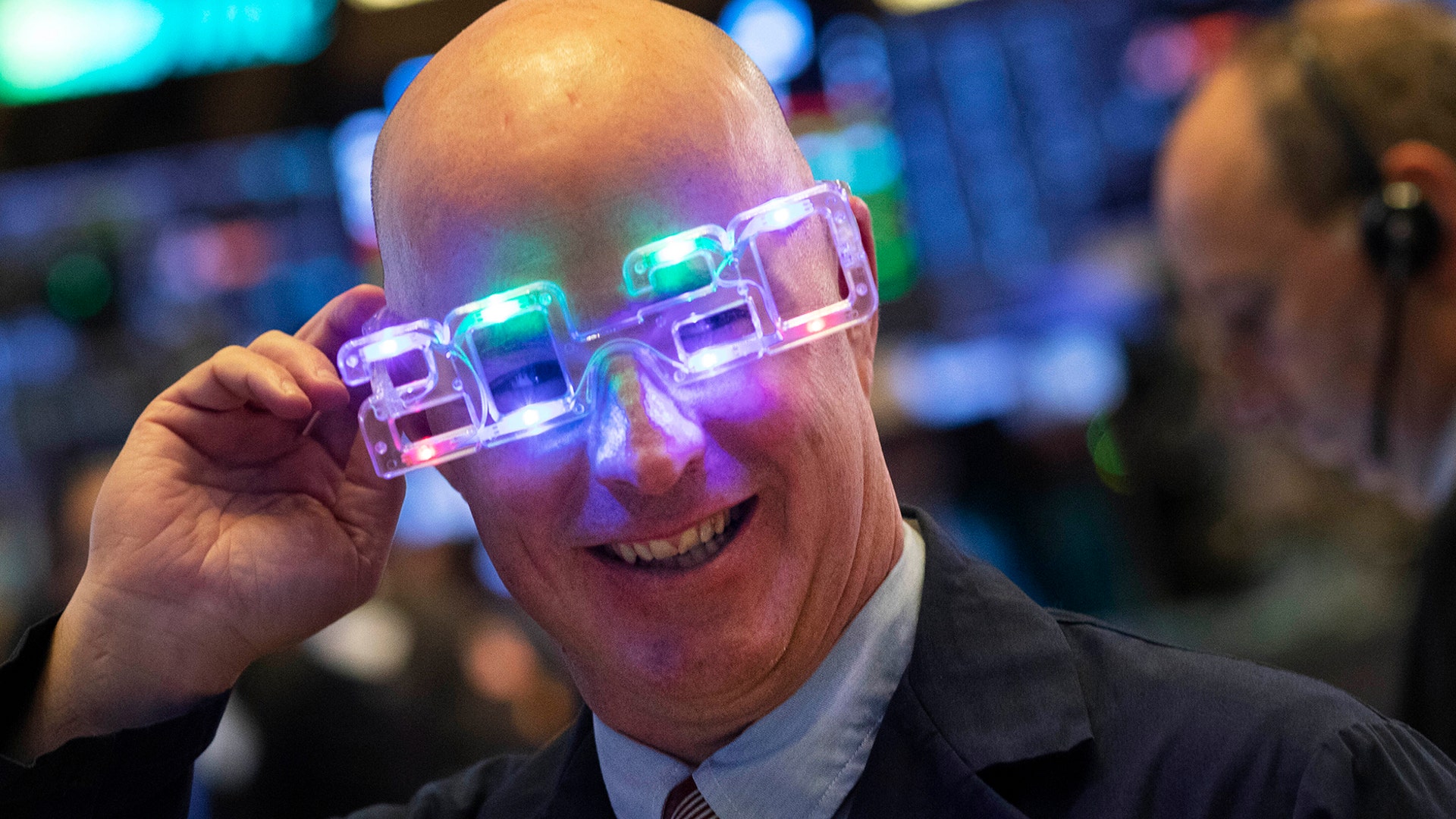 New York: Stock trader John O'Hara tries on his New Year's 2020 party glasses at the New York Stock Exchange. (AP Photo/Mark Lennihan)