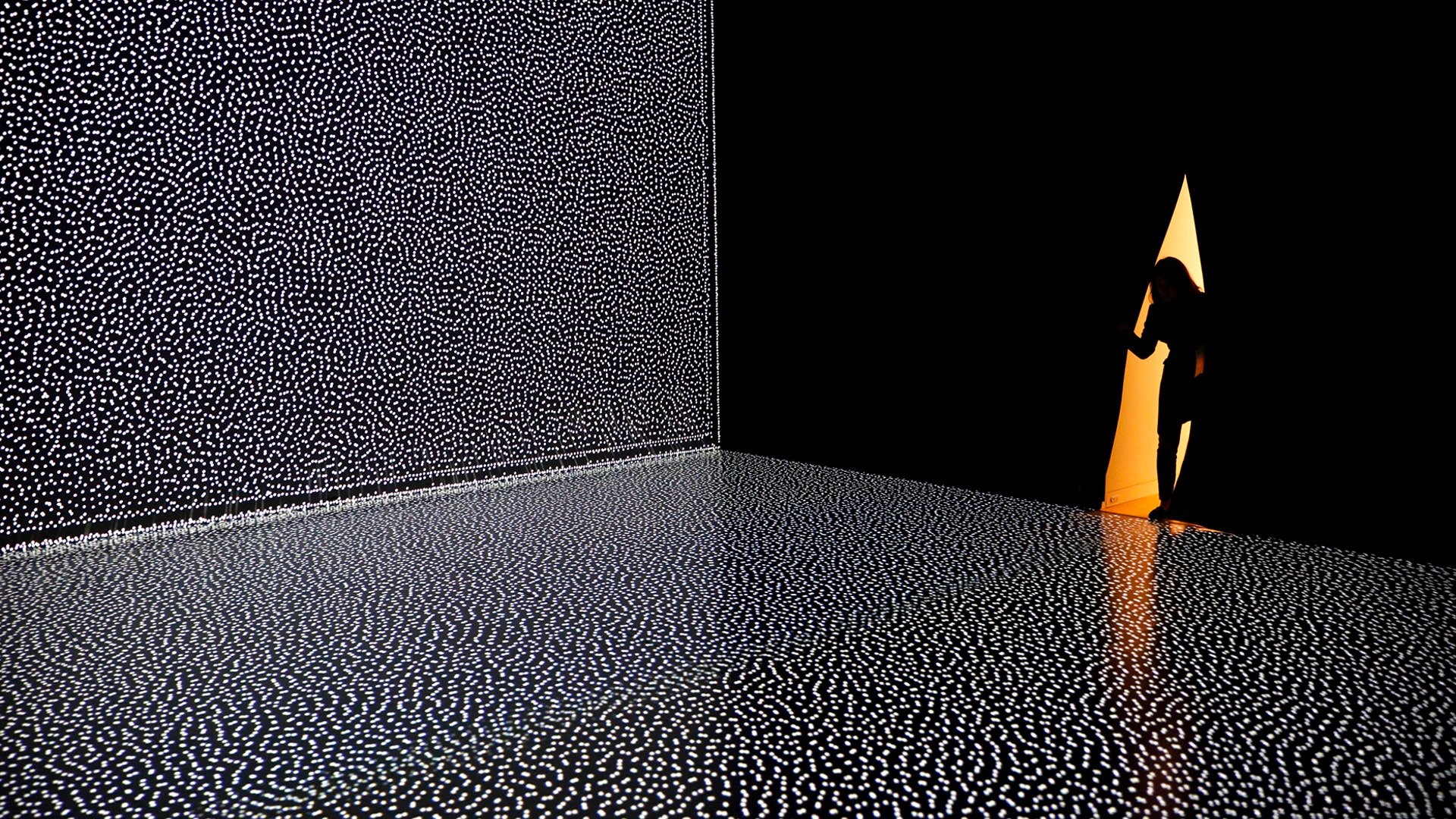 A woman enters an exhibition hall featuring an interactive installation artwork titled "Kinesis #3 – Dissolving Field" by Hiroaki Umeda in Tokyo, Dec. 11, 2019.