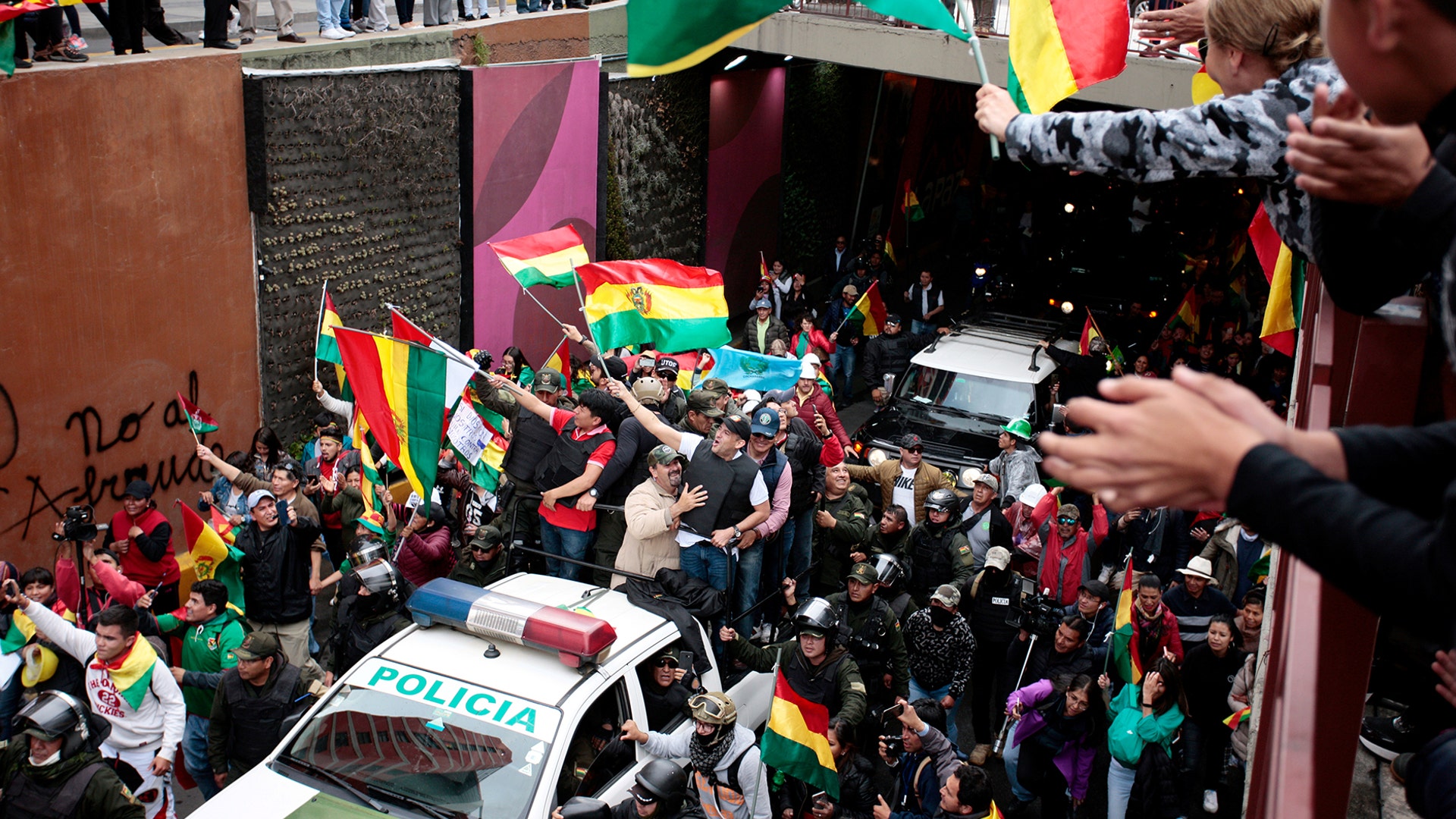 Luis Fernando Camacho, a Santa Cruz civic leader, and major opposition figure, waves to the crowd while riding on the back of a car following the resignation of President Evo Morales in La Paz, Bolivia, Nov. 10, 2019.