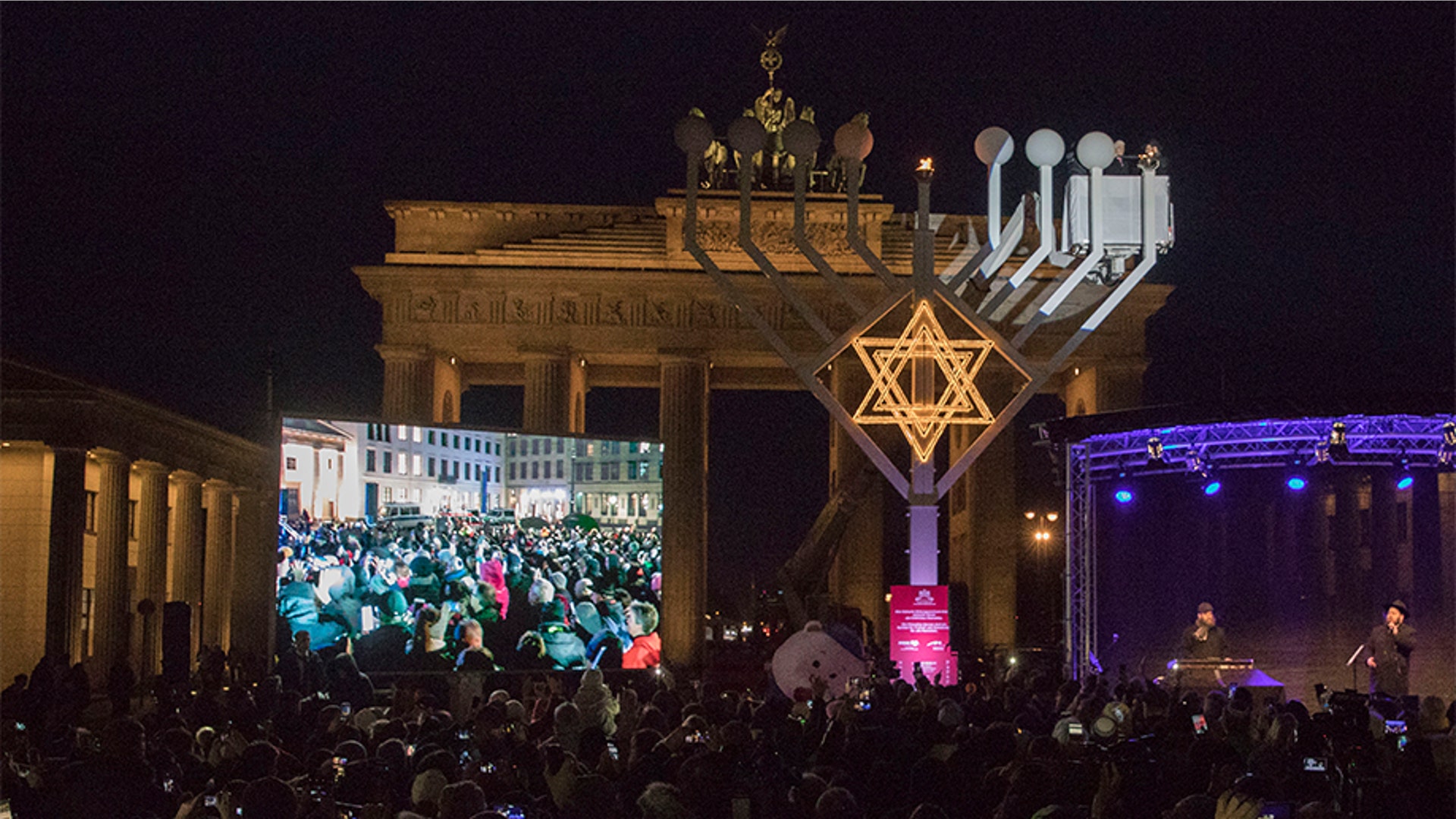 Berlin, Germany: People congregate for a public Menorah ceremony near the Brandenburg Gate.