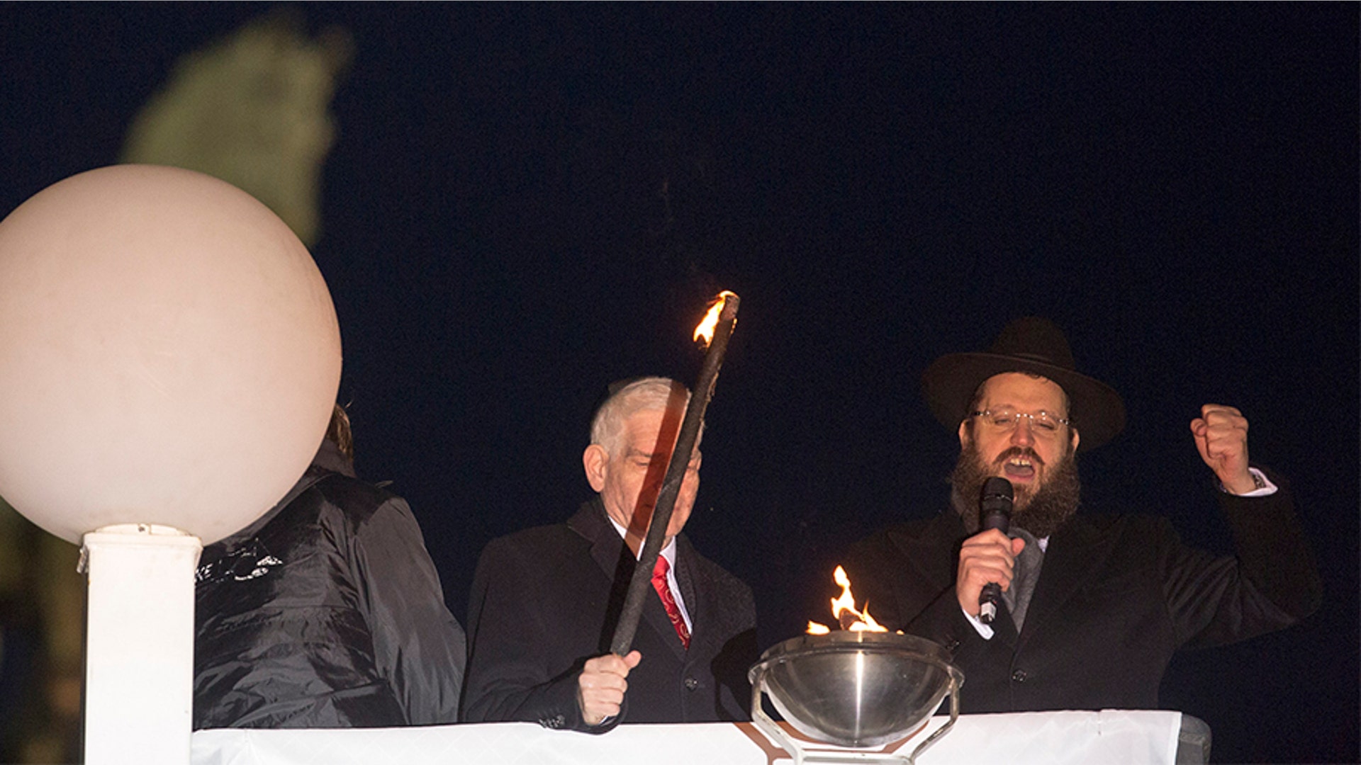 Berlin, Germany: Josef Schuster, left, President of the Central Council of Jews in Germany and Rabbi Yehuda Teichtal light the first lamp of the Hanukkah menorah during a ceremony near the Brandenburg Gate.