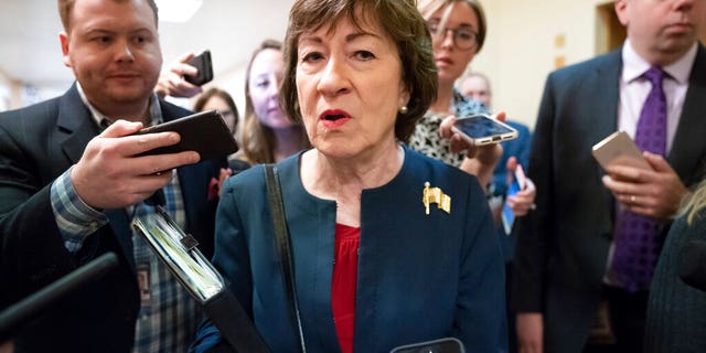 Sen. Susan Collins, R-Maine, is surrounded by reporters as she heads to vote at the Capitol in Washington.  (AP Photo/J. Scott Applewhite)