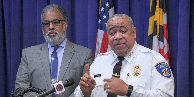 City solicitor Andre Davis, left, listens as Baltimore Police Commissioner Michael Harrison, right, announces support for a pilot program that uses surveillance planes over the city to combat crime on Friday, Dec. 20, 2019, in Baltimore. (Jerry Jackson/The Baltimore Sun via AP)