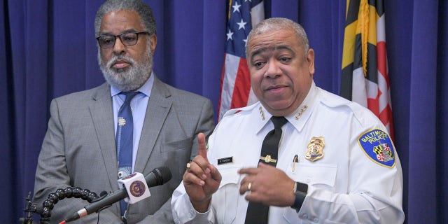 City solicitor Andre Davis, left, listens as Baltimore Police Commissioner Michael Harrison, right, announces support for a pilot program that uses surveillance planes over the city to combat crime on Friday, Dec. 20, 2019, in Baltimore. (Jerry Jackson/The Baltimore Sun via AP)