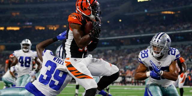 File-This Aug. 18, 2018 file photo shows Cincinnati Bengals wide receiver John Ross, center, making a catch to complete a two point conversion between Dallas Cowboys cornerback Marquez White (39) and safety Jameill Showers (28) during a preseason NFL Football game in Arlington, Texas. (AP Photo/Roger Steinman, File)