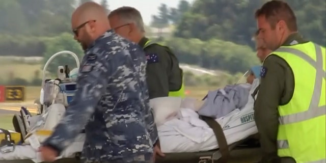 An injured tourist in the volcano eruption is carried to an Australian Air Force plane in Hamilton, New Zealand, Thursday, Dec. 12, 2019. N Australian Broadcasting Corporation via AP