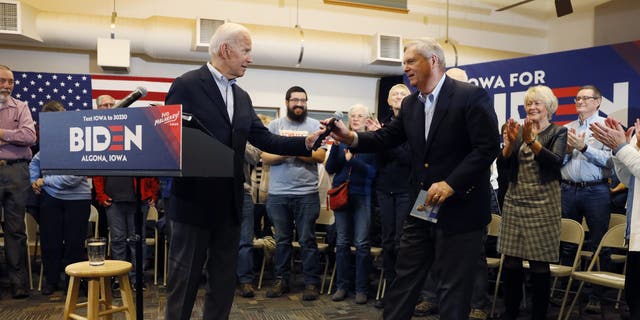 Democratic presidential candidate former Vice President Joe Biden hands the microphone to former Iowa Gov. Tom Vilsack, right, after speaking to local residents during a bus tour stop at Water's Edge Nature Center, Monday, Dec. 2, 2019, in Algona, Iowa. (AP Photo/Charlie Neibergall)