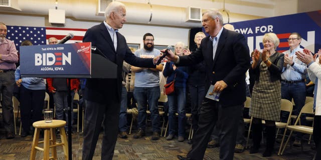 Democratic presidential candidate former Vice President Joe Biden hands the microphone to former Iowa Gov. Tom Vilsack, right, after speaking to local residents during a bus tour stop at Water's Edge Nature Center, Monday, Dec. 2, 2019, in Algona, Iowa. (AP Photo/Charlie Neibergall)