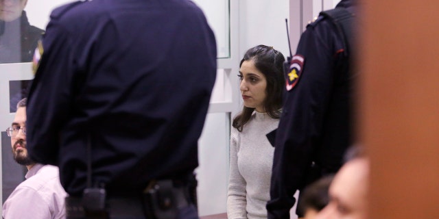 Israeli woman Naama Issachar, center, sits inside a cage during appeal hearings in a courtroom in Moscow, Russia, Thursday, Dec. 19, 2019. Naama was sentenced in October to seven and a half years in prison for drug smuggling after authorities in April found nine grams of marijuana in her luggage.