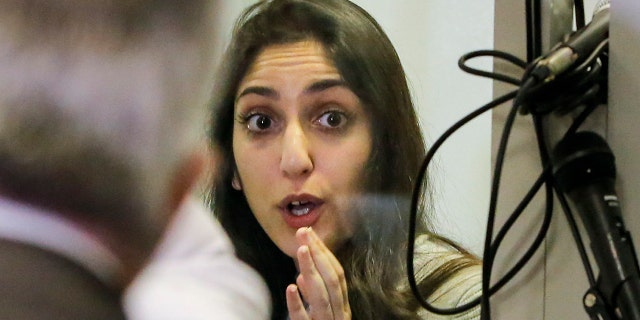 Israeli Naama Issachar gestures during an appeal hearing in a courtroom in Moscow, Russia, Thursday, Dec. 19, 2019. An Israeli backpacker serving prison time in Russia on a drug conviction is appealing her case and says she was wasn't provided a translator or lawyer after being detained at a Moscow airport.