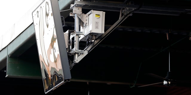 FILE - In this July 10, 2019, file photo, a radar device hangs from the roof behind home plate at PeoplesBank Park during the third inning of the Atlantic League All-Star minor league baseball game in York, Pa.  (AP Photo/Julio Cortez, File)