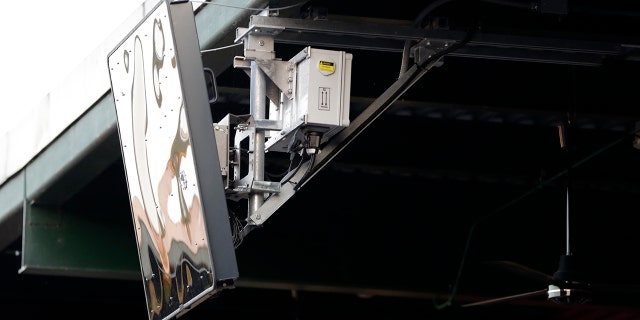 FILE - In this July 10, 2019, file photo, a radar device hangs from the roof behind home plate at PeoplesBank Park during the third inning of the Atlantic League All-Star minor league baseball game in York, Pa. (AP Photo/Julio Cortez, File)