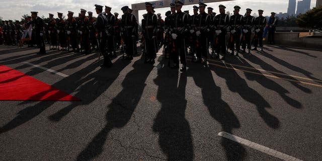 The sun casts the shadows of South Korean soldiers during a welcoming ceremony at Defense Ministry in Seoul.