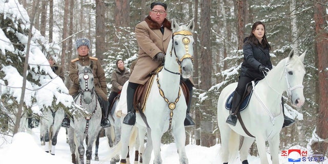 This undated photo provided on Wednesday by the North Korean government shows North Korean leader Kim Jong Un, center, with his wife Ri Sol Ju, right, riding on white horse during his visit to Mount Paektu, North Korea. North Korea says leader Kim has taken a second ride on a white horse to a sacred mountain in less than two months. (Korean Central News Agency/Korea News Service via AP)