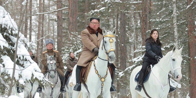 This undated photo provided on Wednesday by the North Korean government shows North Korean leader Kim Jong Un, center, with his wife Ri Sol Ju, right, riding on white horse during his visit to Mount Paektu, North Korea. (Korean Central News Agency/Korea News Service via AP)